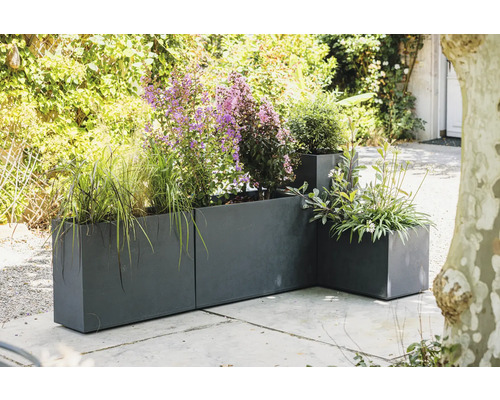 Kovové květináče s různými rostlinami venku