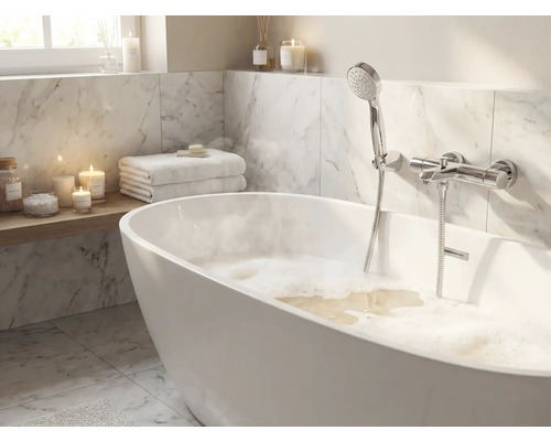 Koupelna s volně stojící vanou, ruční sprchou a mramorovými obklady