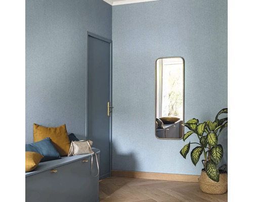 Světlá místnost se vzorovanou tapetou, zrcadlem, dveřmi a posezením