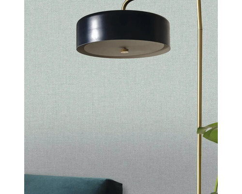 Detailní záběr stojací lampy s textilní tapetou v pozadí