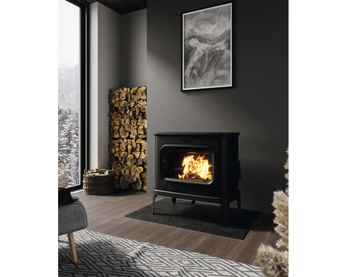 Obývací pokoj s kamny, hromadou palivového dřeva a černobílou fotografií