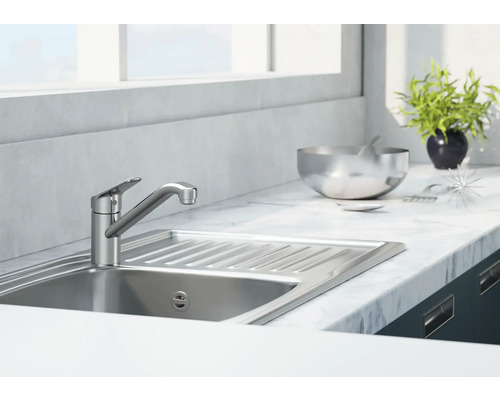 Kuchyňská dřezová baterie z kovu ve světlé kuchyni s umyvadlem