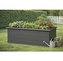 Zvýšený záhon se salátem, bylinkami a rostlinami rajčat, konev a košík s květinami na trávníku