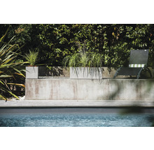 Betonové květináče s výsadbou vedle bazénu a lehátka