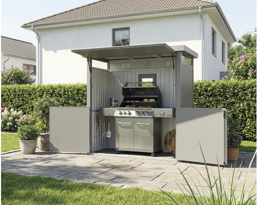 Venkovní snímek grilovacího místa s venkovní kuchyní a grilem na zahradě.
