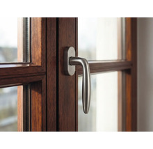 Detail okna s dřevěným rámem a klikou