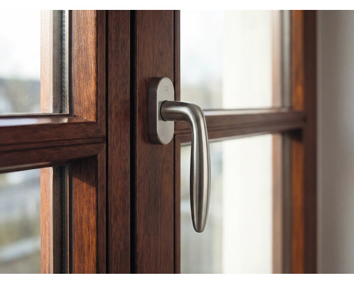 Detail okna s dřevěným rámem a klikou