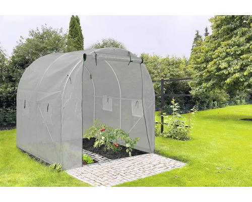 Tunelový skleník na zahradě s rostlinami rajčat