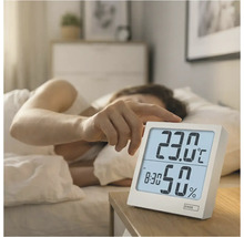 Scéna s vlhkoměrem EMOS na nočním stolku vedle postele