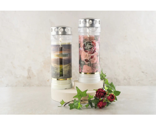 Dva hřbitovní svíčky s křesťanskými motivy, včetně kříže a vzoru růží