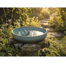 Pítko pro ptáky s ptačí figurkou a vrabcem v zahradě