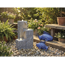 Zahradní scéna s kaskádovou fontánou, okrasnými rybami a rostlinami