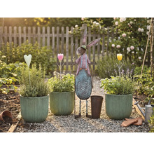 Zahradní scéna s osázenými květináči, kovovým zajícem a dekoracemi na štěrkové cestě