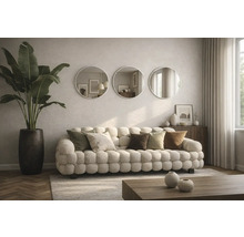 Obývací pokoj s pohovkou, polštáři, kulatými zrcadly a pokojovou rostlinou