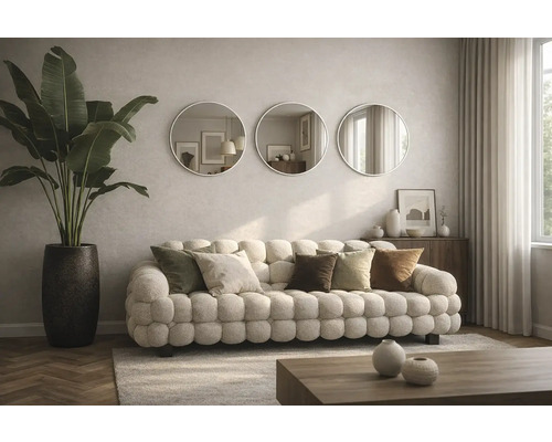 Obývací pokoj s pohovkou, polštáři, kulatými zrcadly a pokojovou rostlinou