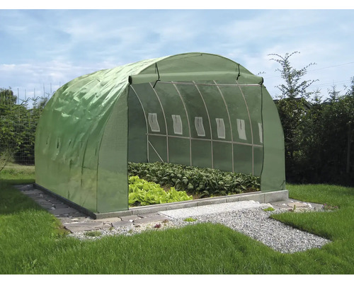 Skleník s rostlinami na zahradě