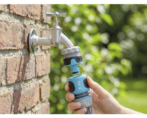 Zahradní scéna s vodovodním kohoutkem, k němuž je v ruce připojen konektor zahradní hadice for_q