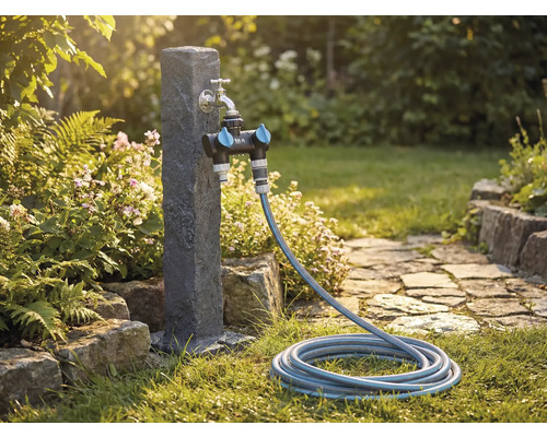 Zahradní scéna s vodovodním kohoutkem, rozdělovačem a zahradní hadicí na trávníku