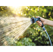 Zahradní hadice se stříkací hlavicí v provozu