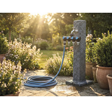 Zahradní scéna s vodním sloupkem, rozdělovačem a zahradní hadicí na kamenné terase