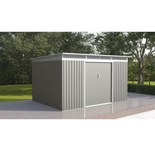 Moderní kovový zahradní domek s dvoukřídlými dveřmi a plochou střechou na dlážděné terase v zahradě se stromy.