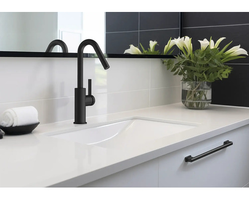 Umyvadlo s černou baterií, ručníkem a vázou s květinami v koupelně