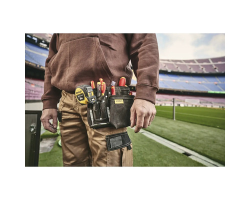 Řemeslník s pouzdrem na nářadí na opasku, plným šroubováků a svinovacího metru od společnosti Stanley