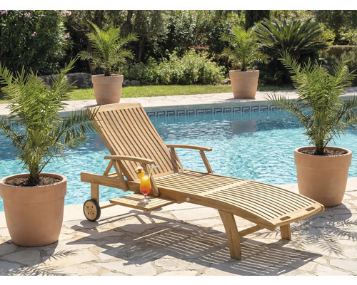 Scéna s dřevěným lehátkem, koktejlem a rostlinami u bazénu.