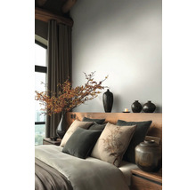 Ložnice s dřevěnou postelí, polštáři, přikrývkami a vázami