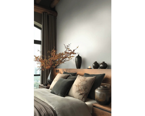 Ložnice s dřevěnou postelí, polštáři, přikrývkami a vázami