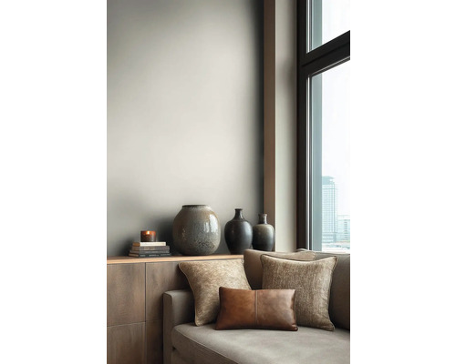 Obývací pokoj s pohovkou, polštáři a dekorativními vázami na příborníku