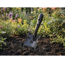 Zahradní rýč for_q v záhonu s květinami