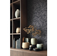 Dekorativní scéna s různými keramickými vázami a tapetou se stromovým motivem na dřevěné polici.