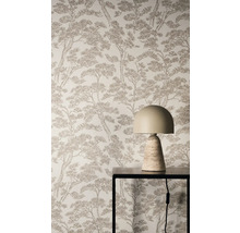 Vliesová tapeta s hnědým vzorem borovic na stěně za moderní stolní lampou na černém kovovém stolku.