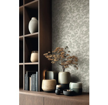 Tapeta s jemným motivem stromů za tmavou dřevěnou policí a různými keramickými vázami.