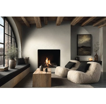 Útulný obývací pokoj s hořícím krbem, dvěma křesly z beránka, konferenčním stolkem z masivního dřeva a dřevěnými stropními trámy.