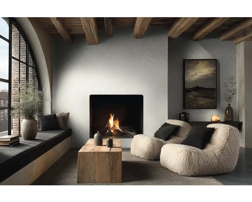 Útulný obývací pokoj s moderním krbem, dřevěnými trámy, dvěma huňatými křesly, rustikálním dřevěným stolkem a velkým klenutým oknem.