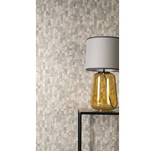 Vliesová tapeta s vertikálním vzorem nepravidelných obdélníků v moderním pokoji se stolní lampou na odkládacím stolku.