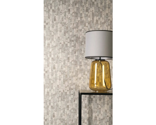 Vliesová tapeta s vertikálním vzorem nepravidelných obdélníků v moderním pokoji se stolní lampou na odkládacím stolku.