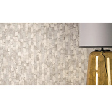 Vliesová tapeta s texturovaným vertikálním vzorem pruhů a metalickými detaily vedle stolní lampy.