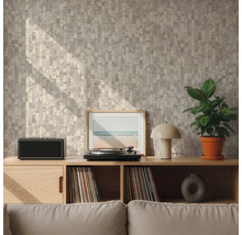 Stěna s geometrickou vzorovanou tapetou v béžové a šedé barvě za dřevěnou komodou s gramofonem a rostlinou ve světlém obývacím pokoji.