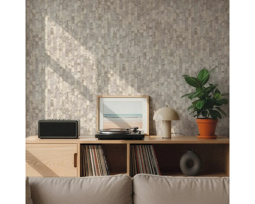 Stěna s geometrickou vzorovanou tapetou v béžové a šedé barvě za dřevěnou komodou s gramofonem a rostlinou ve světlém obývacím pokoji.