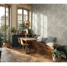 Světlá místnost s květinovou tapetou, dřevěným stolem, lavicí a rostlinami