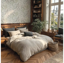 Útulná ložnice s dvoulůžkem, ložním prádlem, polštáři a rostlinami