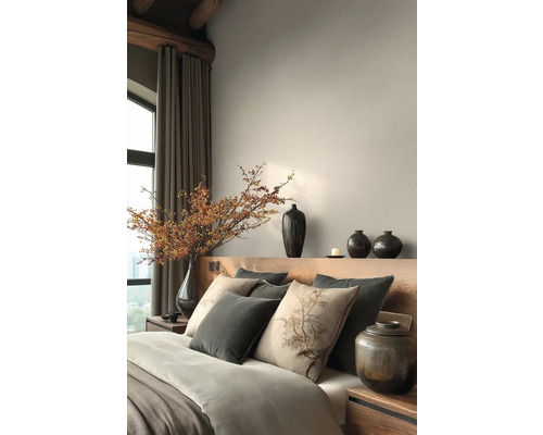 Ložnice s postelí, polštáři, vázami a dekorativními prvky pro klidnou atmosféru