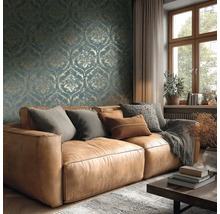 Obývací pokoj s hnědou koženou pohovkou, polštáři, dekou, dřevěným stolem, oknem a vzorovanou tapetou pro útulnou atmosféru