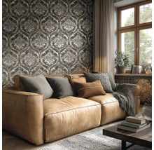 Obývací pokoj s hnědou koženou pohovkou před tmavou tapetou s barokními ornamenty, velkým oknem a útulným zařízením.