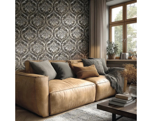 Obývací pokoj s hnědou koženou pohovkou před tmavou tapetou s barokními ornamenty, velkým oknem a útulným zařízením.