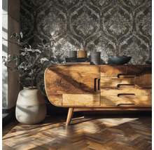 Scéna v obývacím pokoji s vliesovou tapetou s ornamentálním vzorem, dřevěným příborníkem a parketovou podlahou.