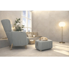 Obývací pokoj s křeslem, stoličkou, stojací lampou a kočkou spící na stoličce